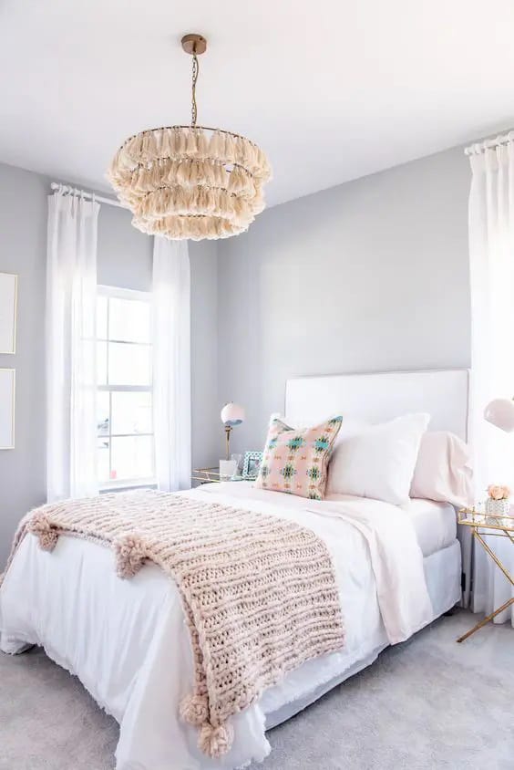 Minimalist white and beige teen bedroom with textured accents and a ruffled chandelier.