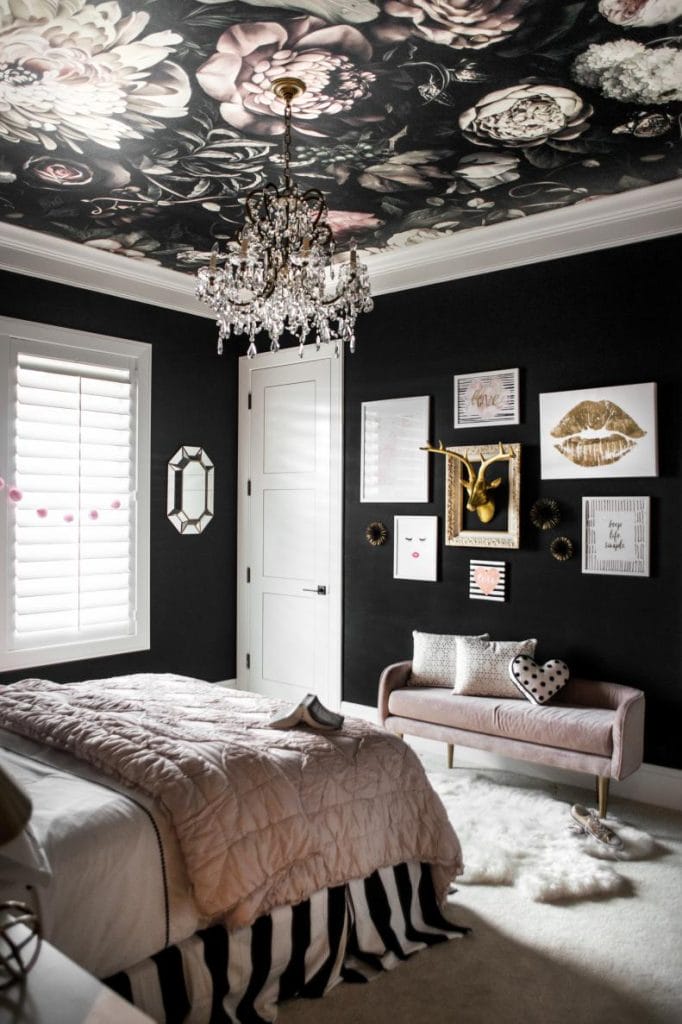 Elegant teen bedroom with dark walls, floral ceiling mural, crystal chandelier, and pink accents.