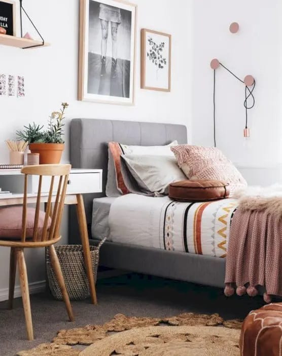 Eclectic room with pink accents, abstract wall art, and patterned bedding.