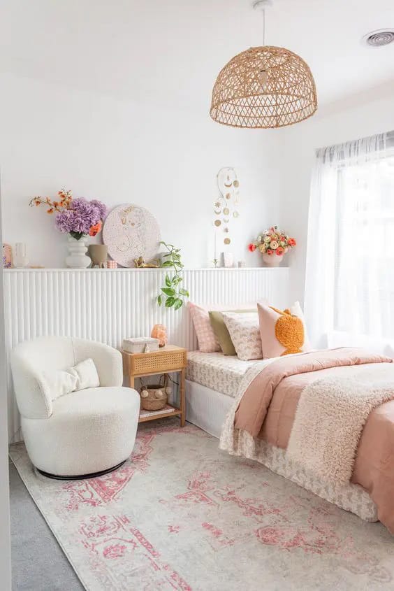 Soft neutral decor with a wicker light fixture, floral accents, and a cozy seating area.