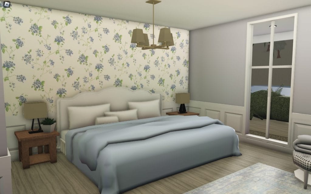 A bedroom with a floral accent wall and light, comfortable furnishings.