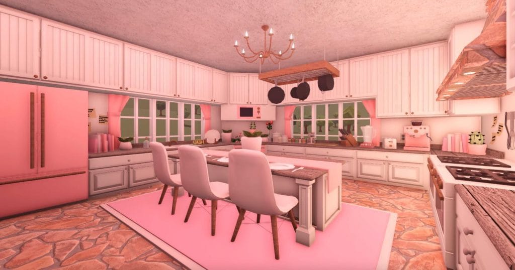 A Valentine's-themed kitchen with soft pink tones, white cabinetry, an island with seating, and a decorative chandelier.