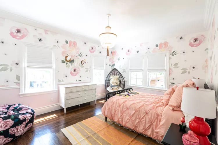 Floral-themed room with bold patterns, bright colors, and a hanging chair.