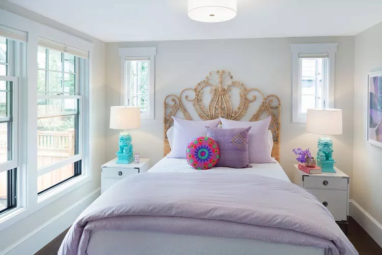 Cheerful room with lavender bedding, turquoise accents, and an elegant headboard.