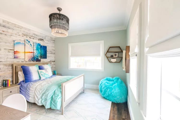 Coastal-themed room with aqua and white accents, turquoise bean bag, and beach decor.