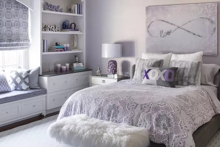 Soft lavender room with elegant accents, plush bedding, and a cozy window seat.