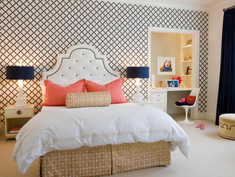 Modern teen bedroom with black and white patterned wall, tufted headboard, and coral accents.