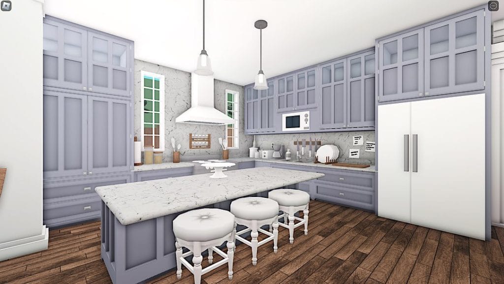 A bright kitchen with pastel-colored cabinets and a marble island with barstools.