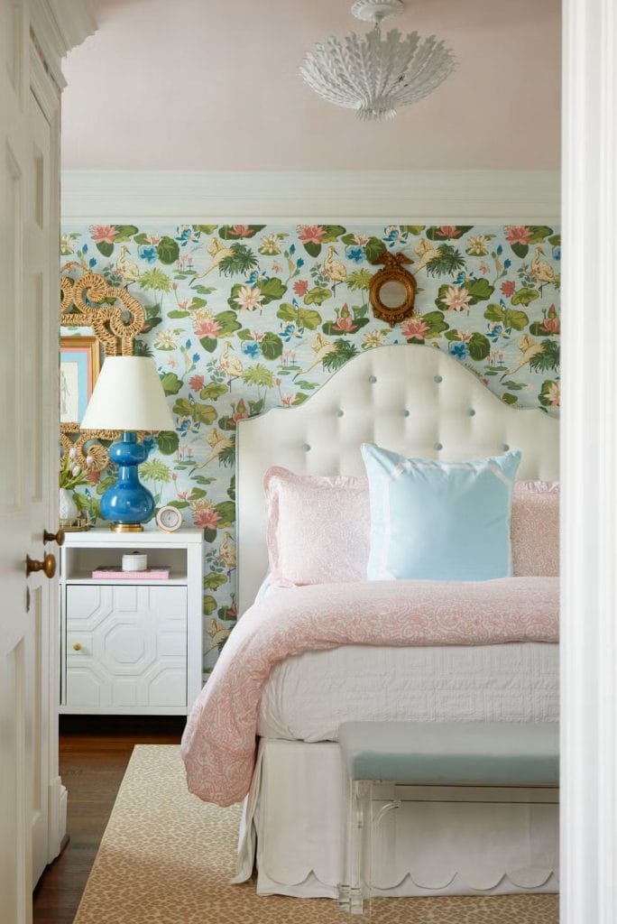 Vintage-style room with floral wallpaper, tufted headboard, and blue accents.