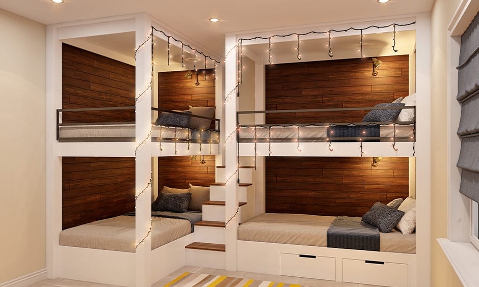 Dorm room with wooden bunk beds and string lights, featuring a rustic cabin-like ambiance.