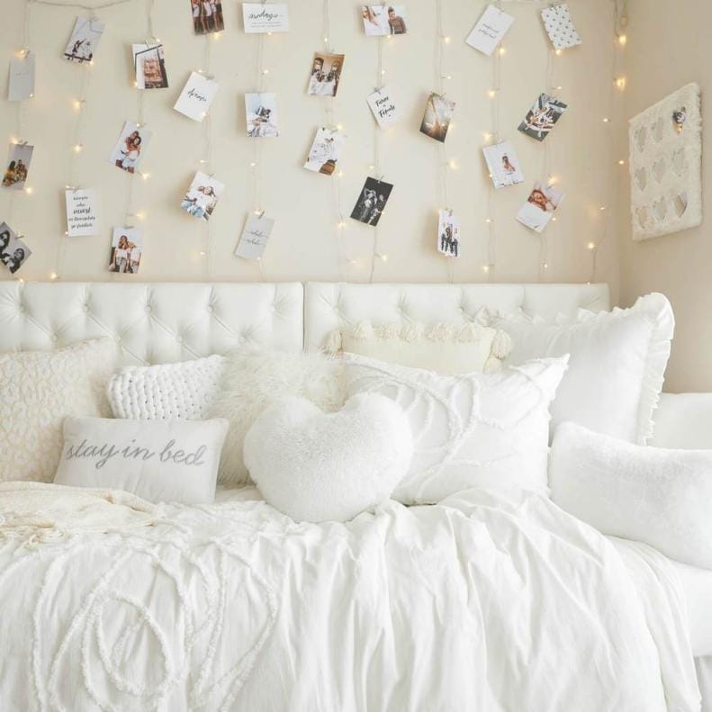 A dorm room with a personalized photo wall, featuring string lights and photo clips to display favorite memories and inspirations.