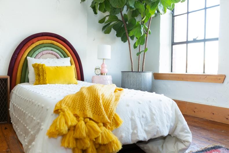 Dorm room with rainbow headboard and yellow accents.