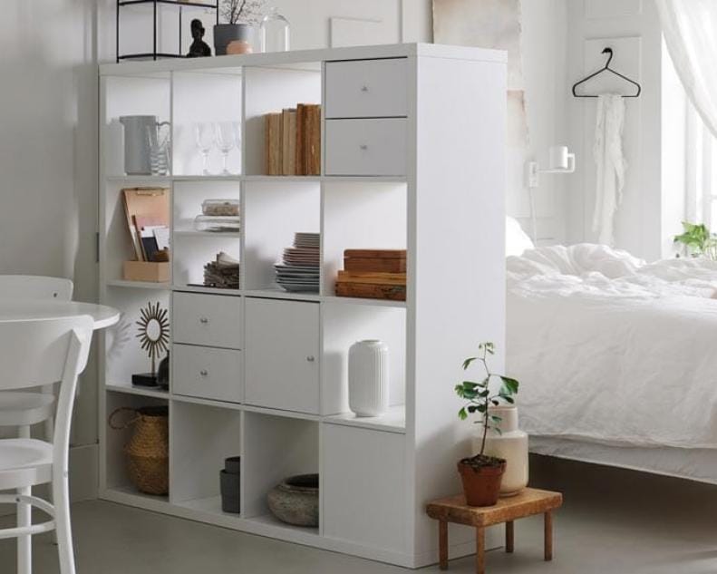 Dorm room with a stylish room divider and organized storage.