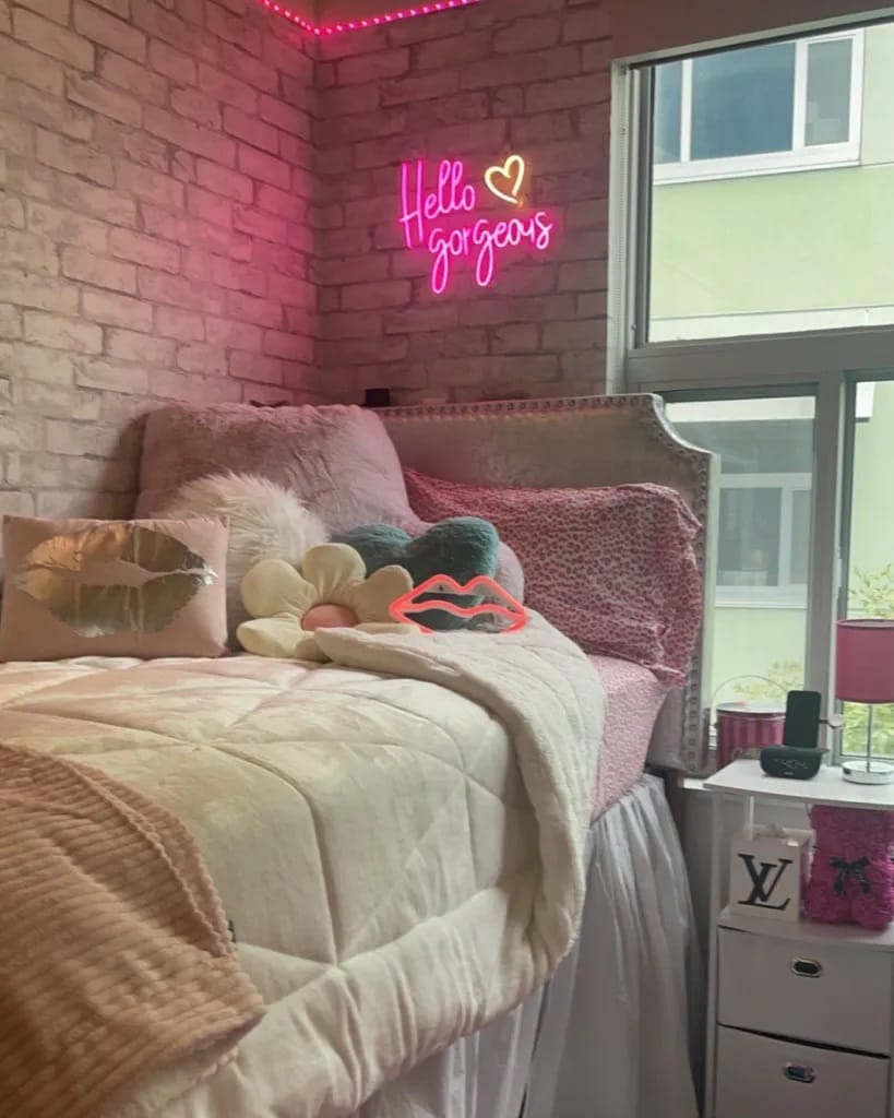 Stylish dorm room with neon signs and plush bedding.