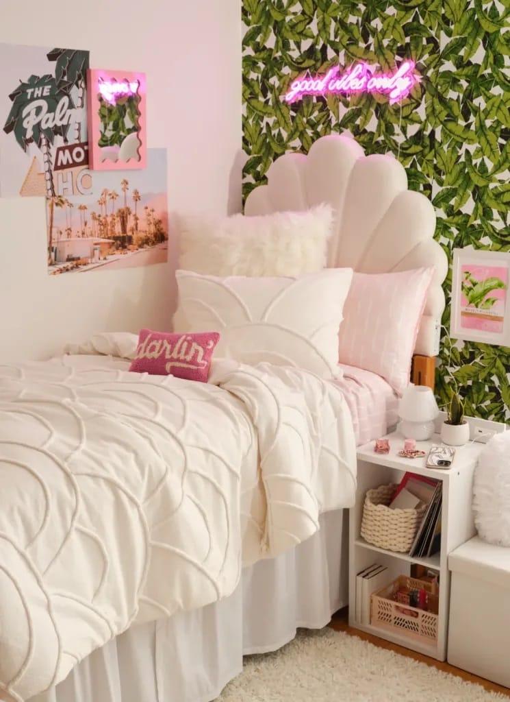 Tropical-themed dorm room with leafy wallpaper and pink accents.