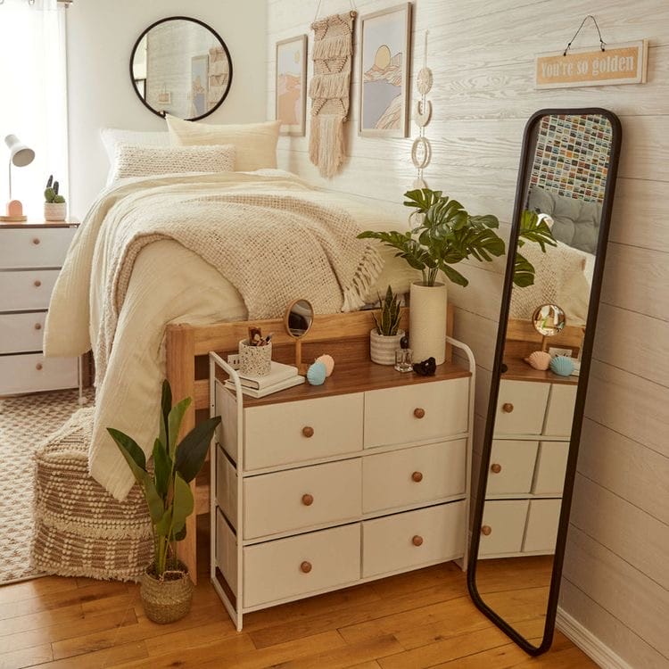  Bed with textured bedding, large mirror, and boho decor with plants.