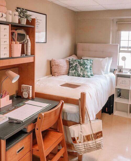 A rustic dorm room with wooden furniture, green accents, and a cozy desk area.