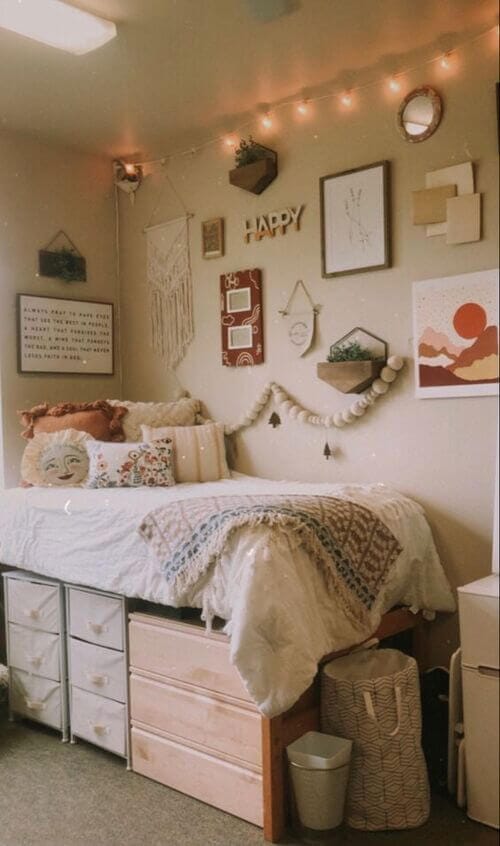 An eclectic dorm room with tapestries, fairy lights, assorted wall art, and cozy bedding.