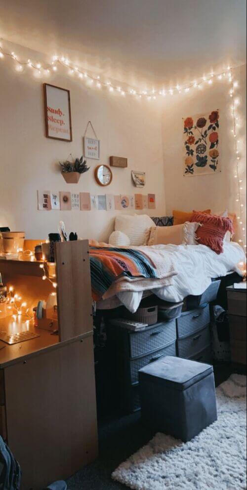 A cozy dorm room with string lights, lofted bed, and vibrant eclectic decor.