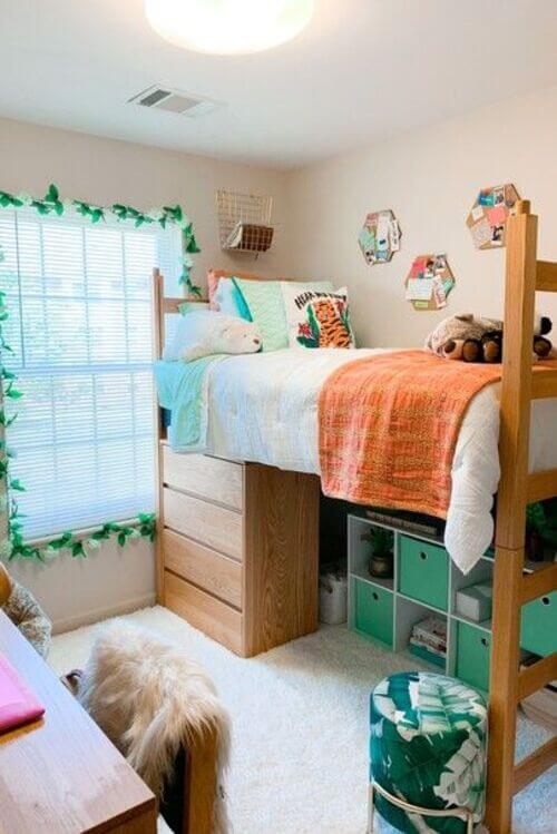 A bright dorm room with a lofted bed, green accents, and functional storage.