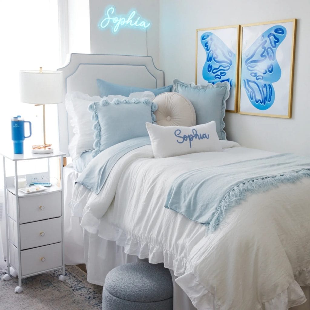 Coordinated twin beds with matching bedding, personalized wall art, and soft blue accents.