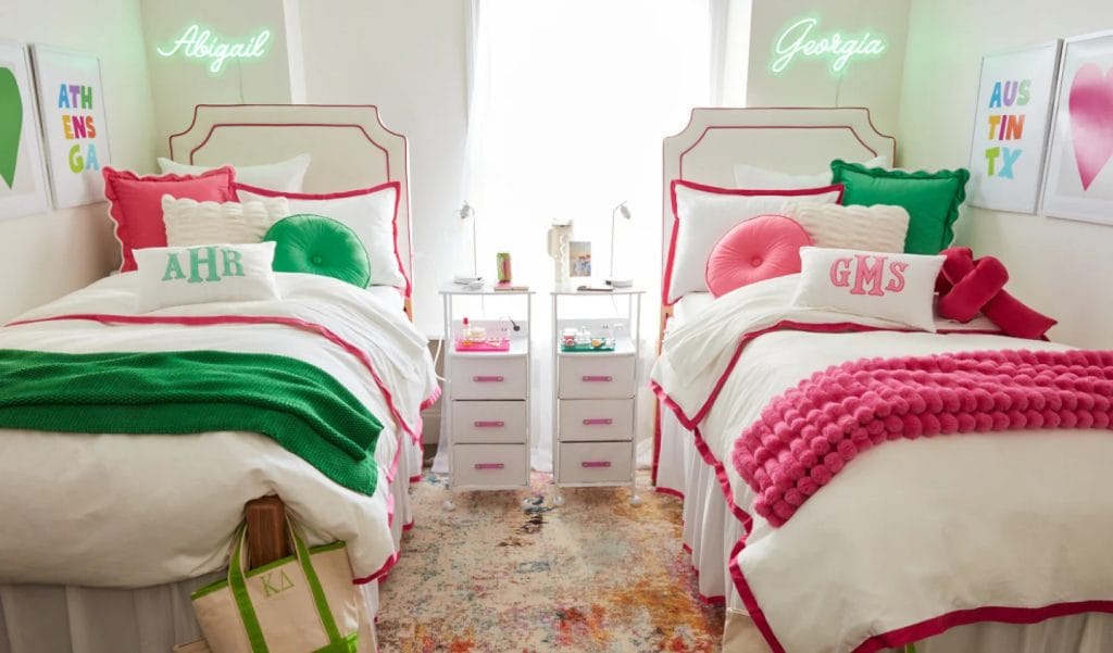 Room with monogrammed twin beds, green and pink decor, personalized touches, and matching bedside tables.