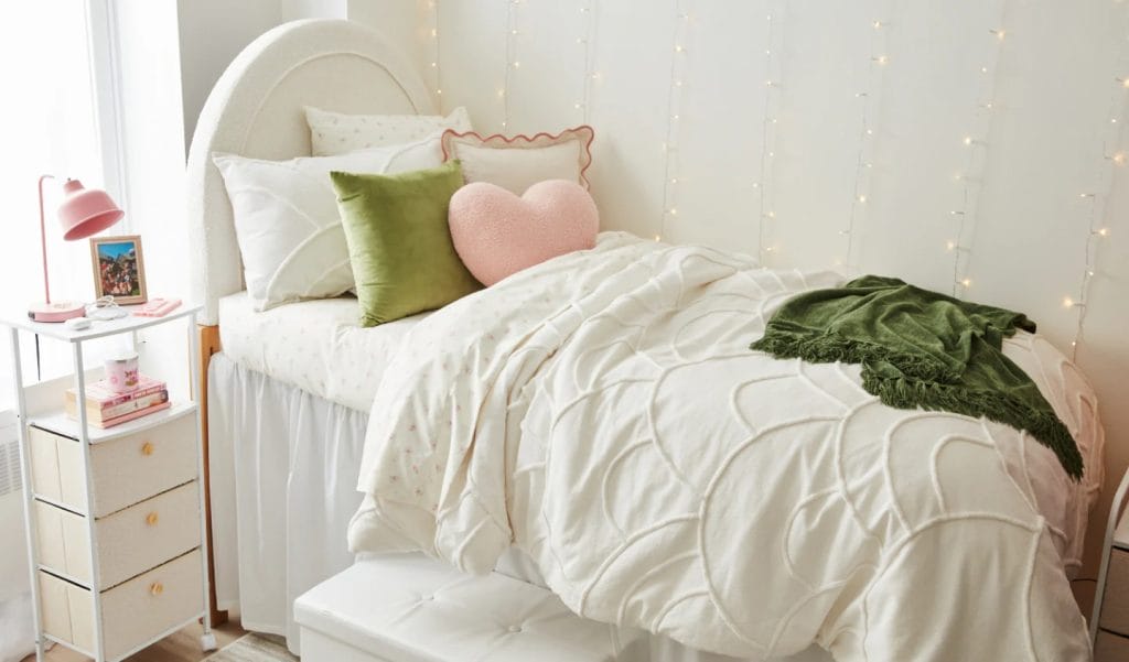 Room with a plush bed, string lights, and green and pink accents.