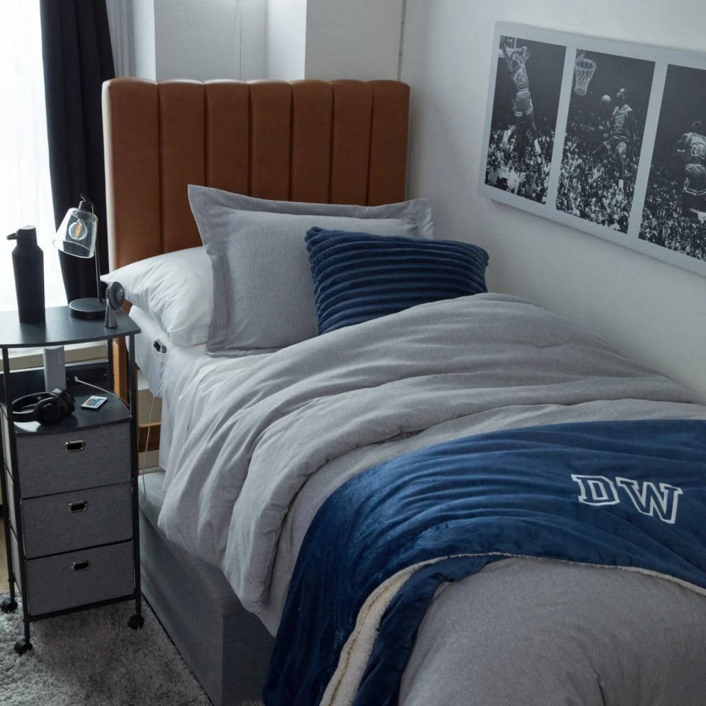 Room with a sleek grey and blue color scheme, plush bedding, and minimalistic decor.