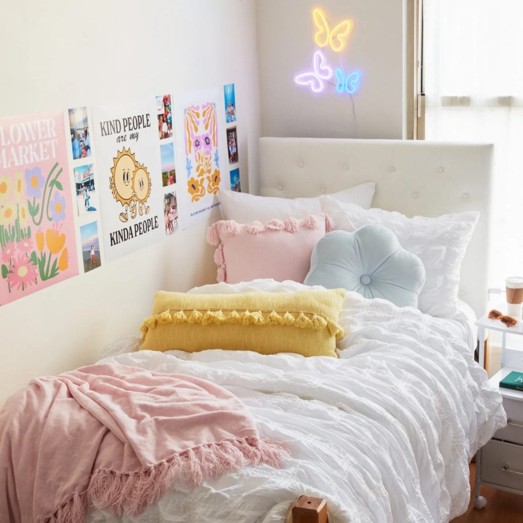 Bed with cozy bedding, under-bed storage, side table, and wall art.