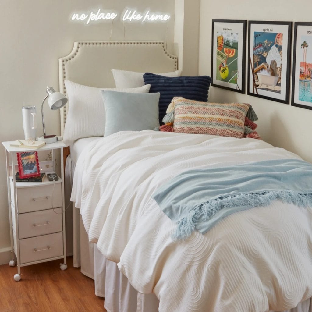 Serene room with neutral colors, soft textures, and a neon "no place like home" sign.