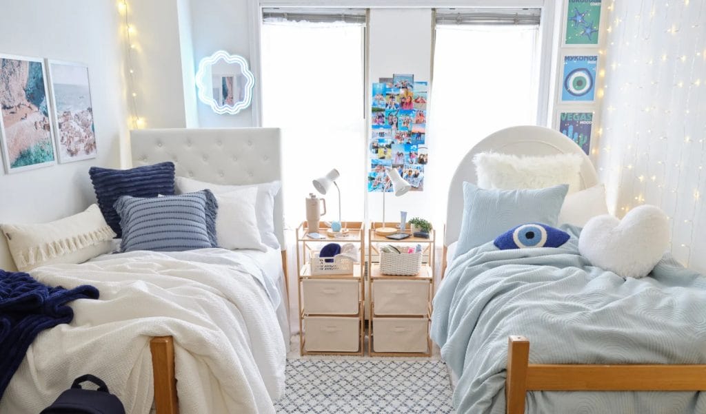 A serene room with twin beds, blue and white bedding, beach-themed wall art, and soft lighting for a coastal-inspired look.