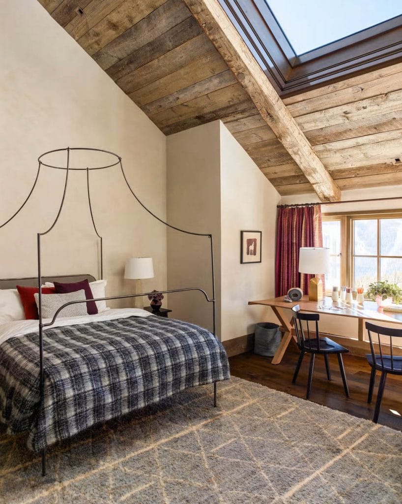 Teen boy's rustic bedroom with a wooden ceiling, plaid bedding, and a skylight.