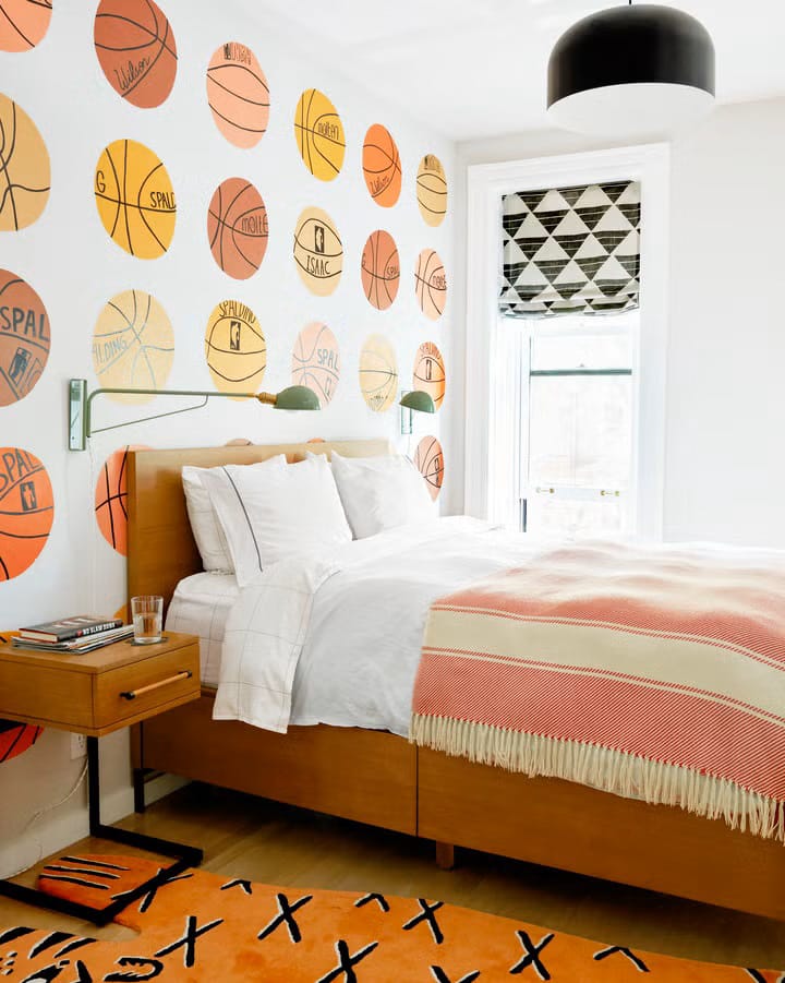 Teen boy's room with basketball-themed wall design and wooden furniture.