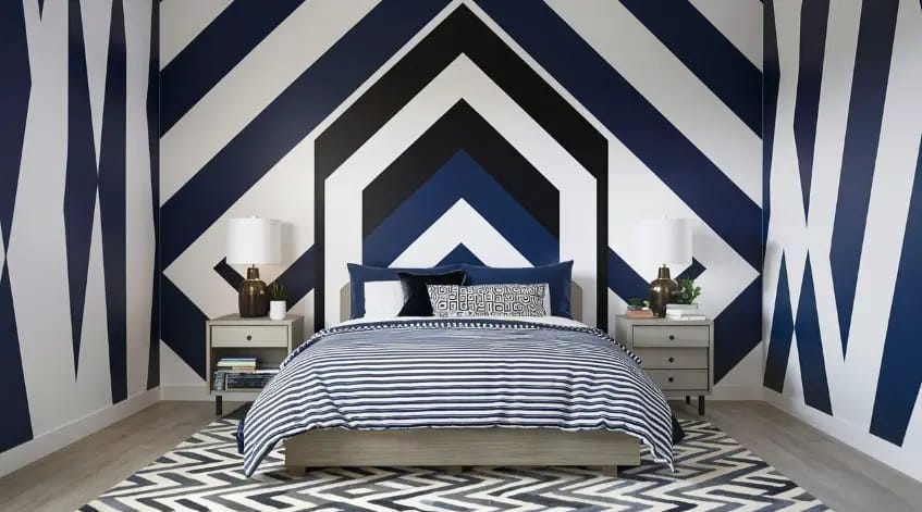 A teen boy’s room with bold black, white, and navy geometric patterns on the walls, complemented by minimalist decor.