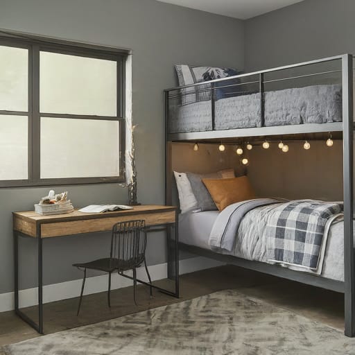 A bedroom with a bunk bed decorated with string lights, a simple wooden desk, and a cozy, warm atmosphere.