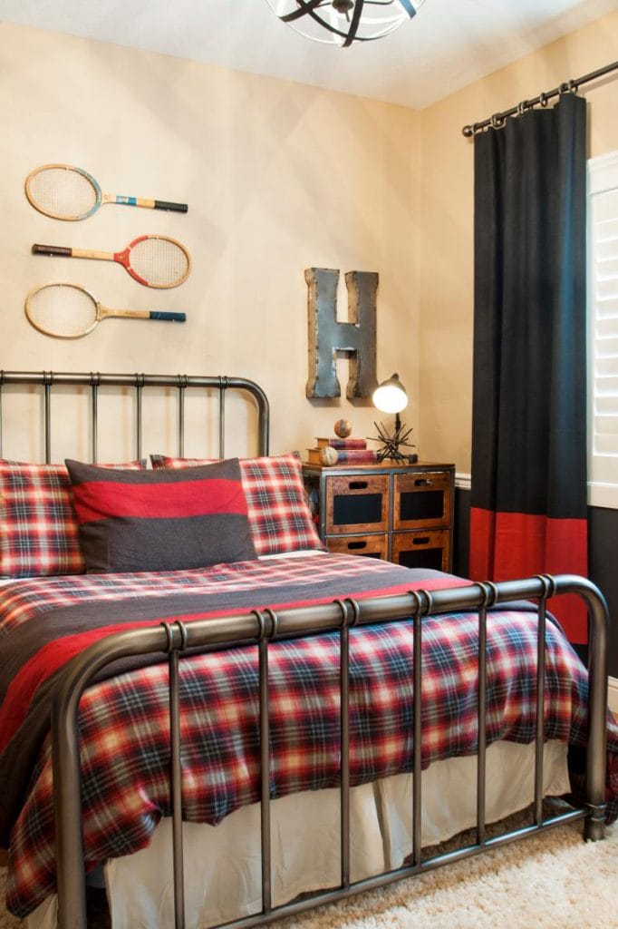 Teen boy's room with plaid bedding, retro tennis rackets on the wall, and rustic decor.