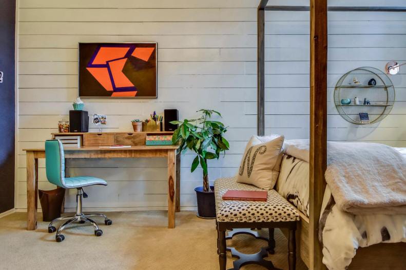 Teen boy's room with rustic wooden furniture, shiplap walls, and abstract art.