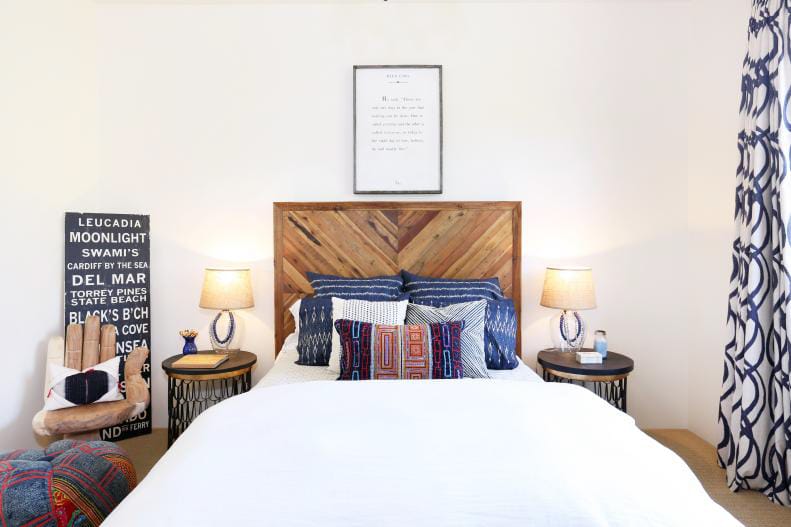 Bedroom with a rustic wooden headboard, boho textiles, and a cozy atmosphere.