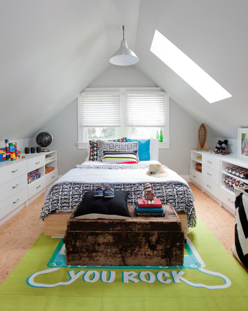 A bright teen boy's attic bedroom with a "You Rock" rug and colorful decor.