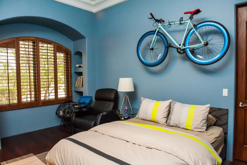 Teen bedroom with a wall-mounted bicycle and blue decor.