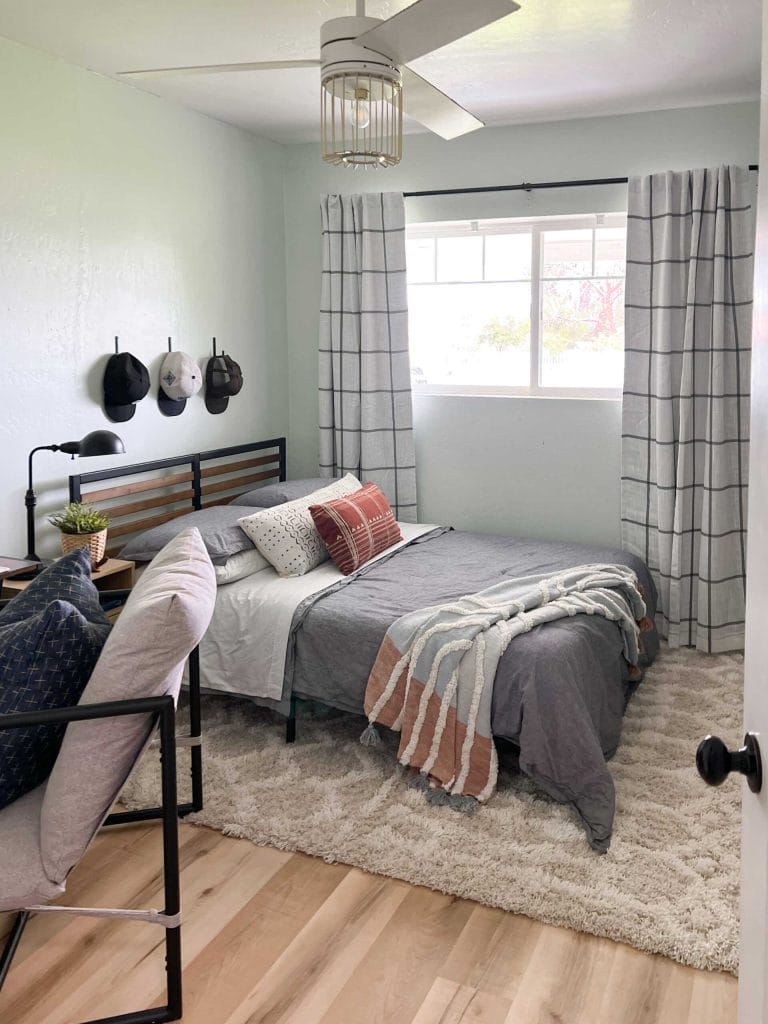 Minimalist gray bed with rugged accents in a teen boy's room.