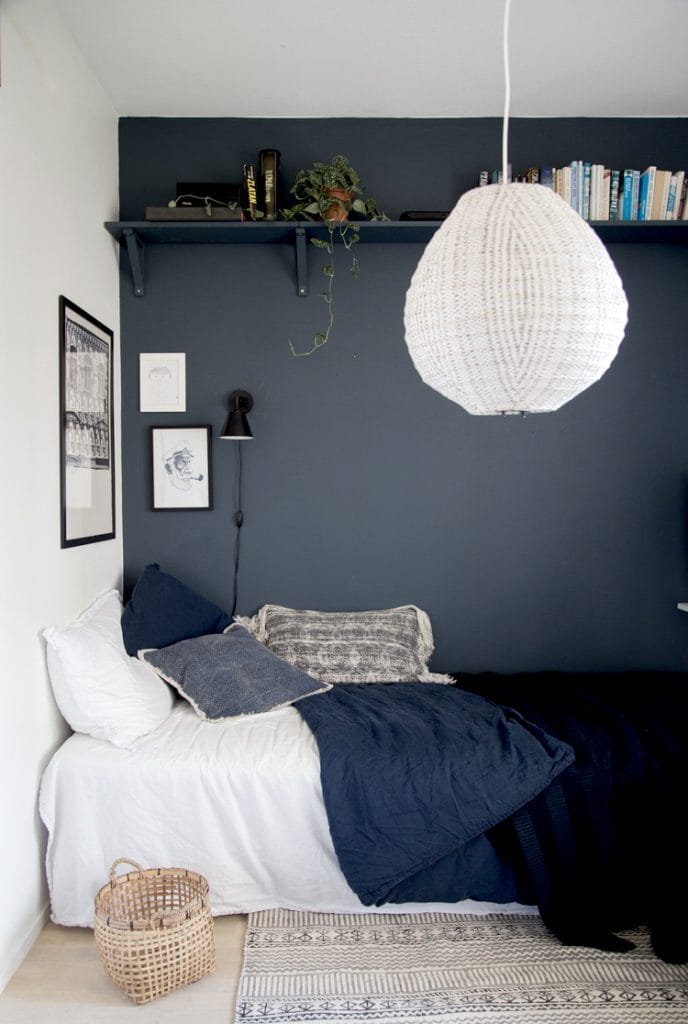 Cozy bed with a dark accent wall in a teen boy's room.