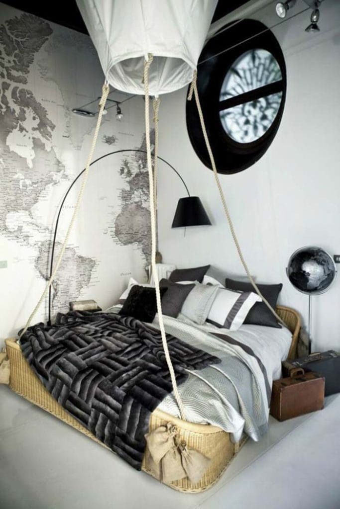 A teen boy's bedroom with a hot air balloon-themed bed and a wall map.