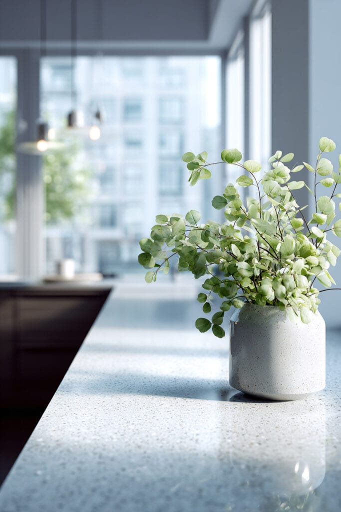 Minimalist organic modern kitchen with eucalyptus stems, neutral ceramic vase, clean white countertop, and bright natural light