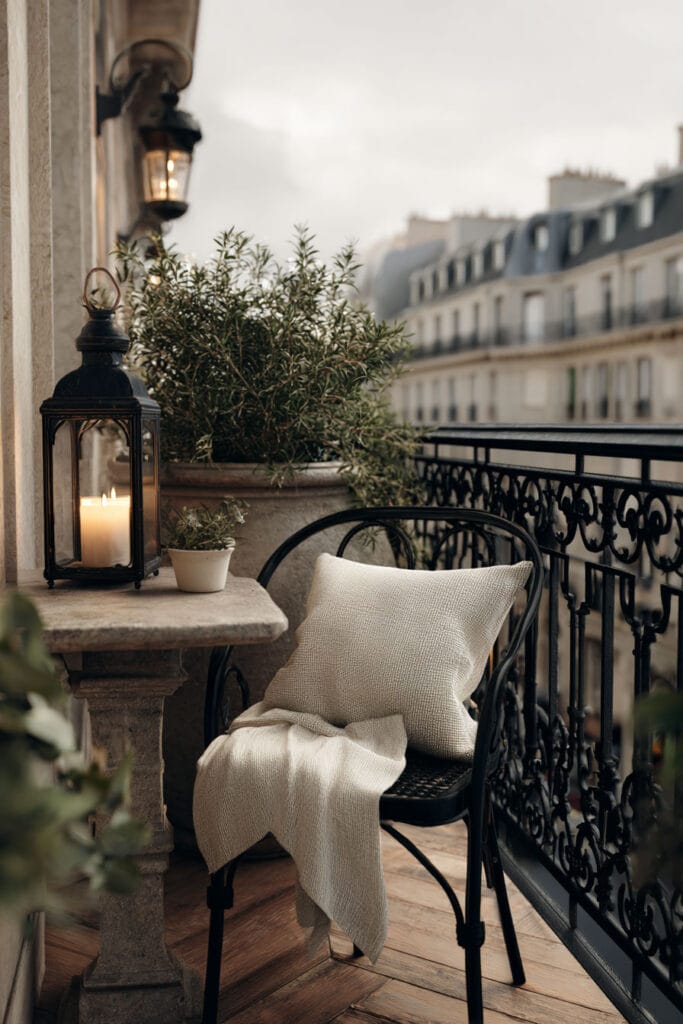 Paris balcony with lantern, wrought iron chair, linen throw, ornate railing, and cozy hidden café atmosphere